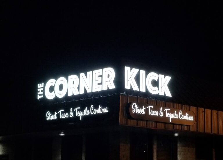 The Corner Kick restaurant sign lit up at night
