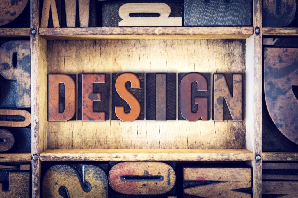 The word "Design" written in vintage wooden letterpress type.
